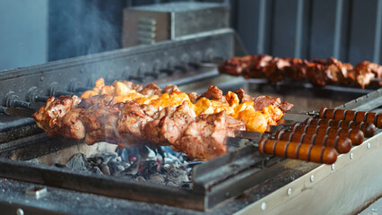 Grilled meat skewers on auto grill, summer barbecue outdoor concept