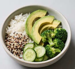 Healthy Vegan Bowl with Rice, Quinoa, Avocado, Broccoli, and Cucumber Plant-Based Meal in Ceramic Dish