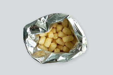 Corn sticks in an open foil bag. White background.