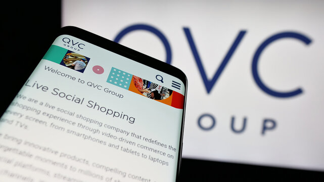 Stuttgart, Germany - 06-07-2025: Mobile phone with website of US media company QVC Group Inc. on screen in front of logo. Focus on top-left of phone display.