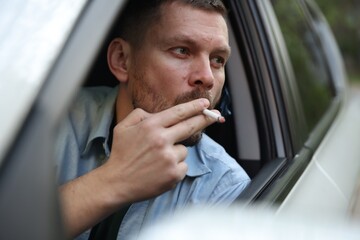 Man smoking cigarette in car, view from outside