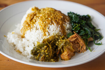 Nasi Padang, Indonesia, captured on June 16, 2025. A traditional Minangkabau rice dish served with a variety of flavorful side dishes such as rendang, vegetables, sambal, and curry sauces.