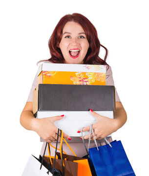 Excited young woman shopaholic holding shopping boxes and bags as much wanted gifts for holidays. Surprised female opem mouth reaction