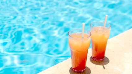Two cocktails made of natural juice in the pool