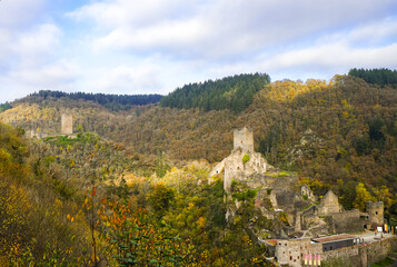 View of the autumn landscape and the Manderscheid Castles near the Eifel town of Manderscheid. Two castle ruins in the forest.