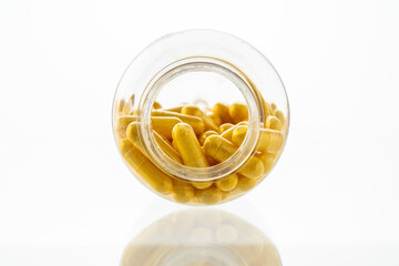 A jar with pills inside lies on a white background. Hyaluronic acid, collagen, vitamins or barberry...