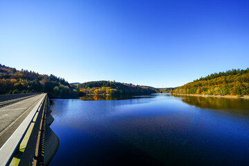 Obraz premium View of the Oleftalsperre Dam and the surrounding landscape. Nature at the lake near the Eifel National Park near Hellenthal in the Hohes Venn-Eifel Nature Park. 