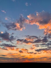 Beautiful orange sunset. The sun's rays look through the clouds. Evening hour.