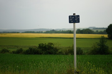 Depth marker in front of scenic farmland and hills
