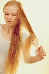 Blonde girl brushing her long hair