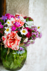 Bouquet of beautiful wild summer flowers on a window background