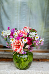 Bouquet of beautiful wild summer flowers on a window background