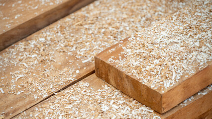 Sawdust spreading on timber stack in the wood workshop. Wooden dust from planing and sawing timber. Wood production waste. lumber industry concept