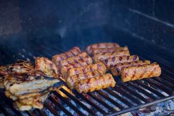 (Mici), traditional Romanian meat dishes on a grill during the cooking