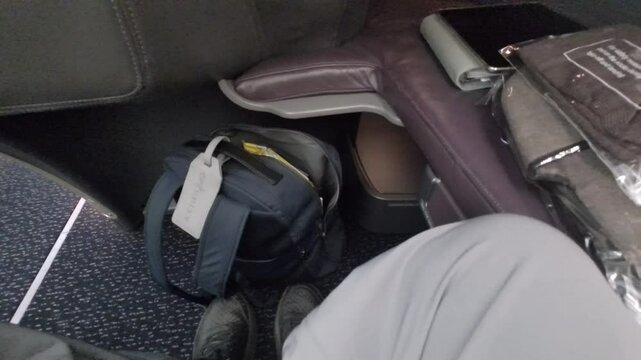 Ample leg room in a business class seat on a long-haul flight.