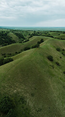 Drone view of rolling green hills in Zagajicka brda in spring season, with scattered trees and a...
