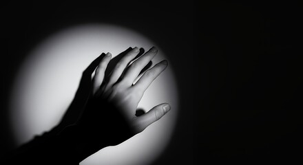 Reaching Hand in Dramatic Light Black and White Artistic Concept