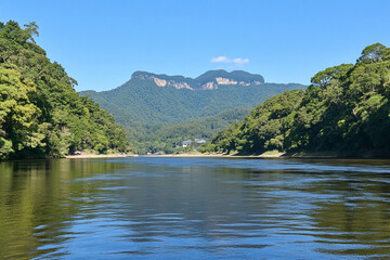 Majestic mountain range rising above a tranquil river landscape