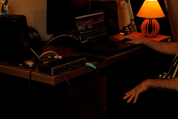 Produtor trabalhando em home studio com interface de áudio e laptop / Producer working in home studio with audio interface and laptop