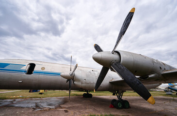 Vintage Propeller Plane Parked Under Cloudy Sky on an Airfield
