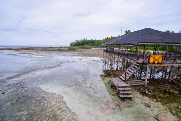 Tropical Beach Hut on Stilts Over Shallow Water During Low Tide