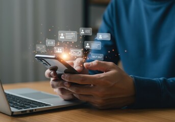Man uses his smartphone with message icons floating above near a laptop on a desk