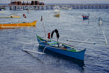 Traditional Outrigger Boats Docked on a Calm Coastal Seaside Harbor