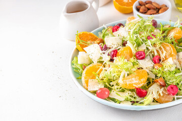 Salad bowl with lettuce, tangerines, nuts and cranberry