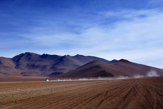 Distant view of a 4x4 Driving through the Siloli Desert in the Atacama Desert, Potosi, Bolivia