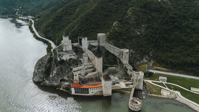 Aerial view of Golubac Fortress on rocky cliff above the Danube River in Serbia, surrounded by water and medieval towers. The most popular and beautiful fortress in Serbia on the border with Romania