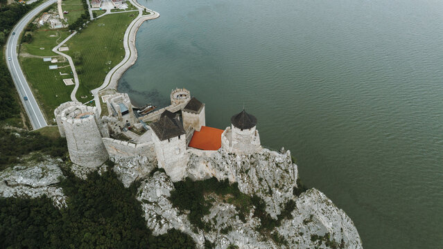 Aerial view of Golubac Fortress on rocky cliff above the Danube River in Serbia, surrounded by water and medieval towers. The most popular and beautiful fortress in Serbia on the border with Romania
