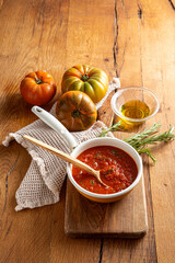 Fried tomato sauce with tomatoes on wood background