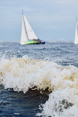 Sailing regatta in the Gulf of Finland at sunset, sailing yacht competing in a race, splashing...