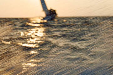 Sailing regatta in the Gulf of Finland at sunset, sailing yacht competing in a race, splashing...