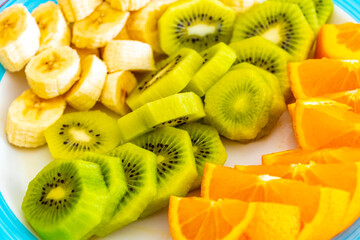 Sliced oranges kiwi and bananas on a plate in Austria.