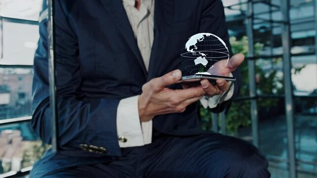 Businessman wearing blue suit is holding smartphone with rotating holographic projection of planet earth floating on top, showing global business and metaverse concepts