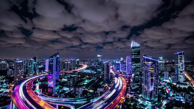 Light trails illuminate the busy highways weaving through the vibrant cityscape of jakarta, indonesia, at night, creating a mesmerizing display of urban energy and dynamism under a cloudy sky