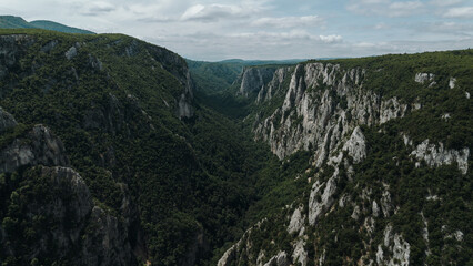 Aerial view of Lazar Canyon - Lazarev Kanjon in eastern Serbia, showcasing dramatic limestone cliffs covered in lush green forest. One of the most beautiful and wild canyons in the Balkans