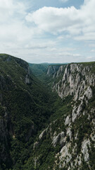 Aerial view of Lazar Canyon - Lazarev Kanjon in eastern Serbia, showcasing dramatic limestone cliffs covered in lush green forest. One of the most beautiful and wild canyons in the Balkans