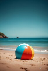 Obraz premium Beach Ball on Sandy Shore with Calm Blue Ocean Under Clear Sky
