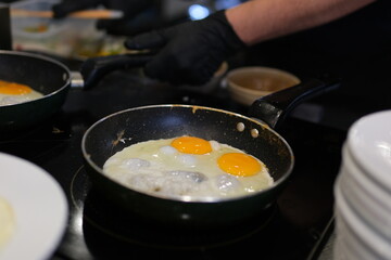 fried eggs with chives in an iron pan on a wooden table. High quality photo