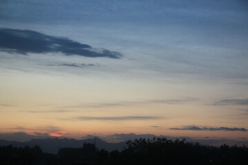 Fototapeta premium A serene sunset scene with a gradient sky transitioning from deep blue to soft orange and pink near the horizon