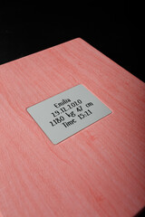 Photobook, photo album in pink leather cover on black background with metallic shield, inscription...