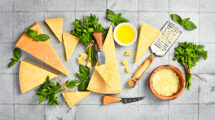 Large set of aged cheese. Top view on a gray stone background. Close-up. Aged cheese cut into...