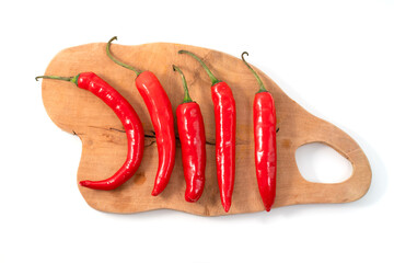 Top view of a collection of Large Red Chili Peppers on a wooden cutting board Isolated on a White...