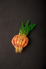 Fabric green onion brooch on black wooden background. recycling and upcycling concept. Funny...