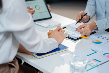 financial asian advisor showing plan of investment to clients in the consultancy office.