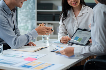 Business team using a calculator to calculate the numbers of statistic business profits growth rate on documents graph data, desk in the office.