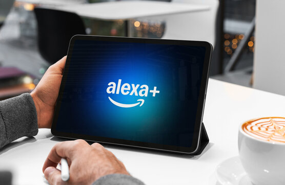Businessman using tablet showing alexa plus app in a cafe