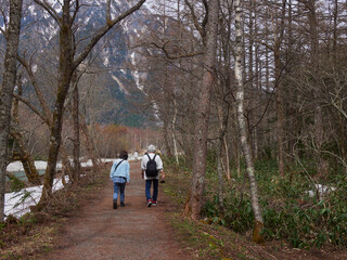 Obraz premium 初夏の観光名所上高地の穂高連峰と梓川の風景と散歩する観光客の姿